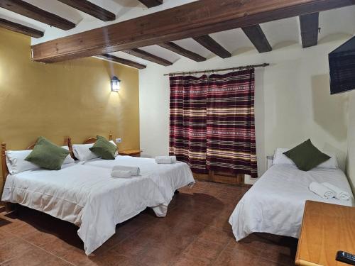 a bedroom with two beds and a window at Hostal Rural Zorita in Zorita del Maestrazgo