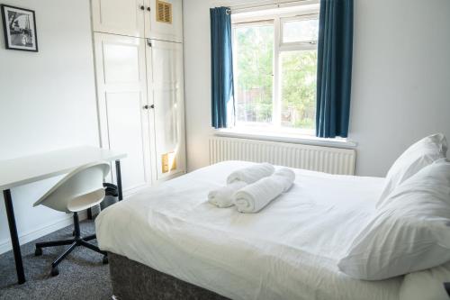 a bedroom with a bed with towels on it at Berry Mansions - Comfort & Style in Wyken