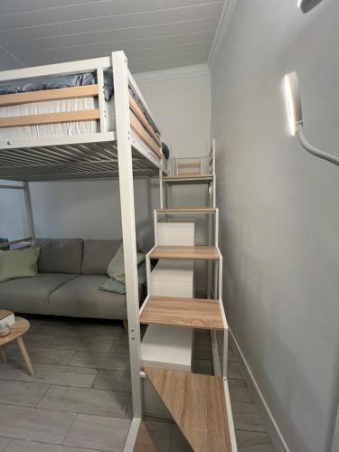 Cette petite chambre comprend des lits superposés et un canapé. dans l'établissement Ô Cocon d Océane, à Nîmes
