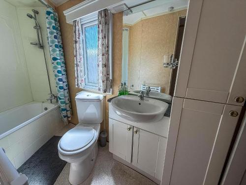 a bathroom with a white toilet and a sink at 6 Berth Caravan For Hire With Sea Views At Haven Seashore Ref 22087A in Great Yarmouth