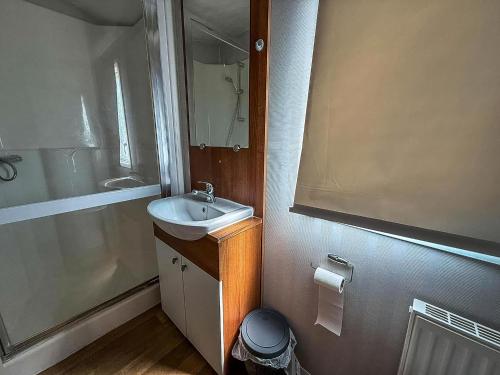 a small bathroom with a sink and a shower at 8 Berth Caravan With Decking At California Cliffs Near Scratby Beach Ref 50019F in Great Yarmouth