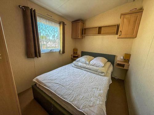 a small bedroom with a bed with two pillows on it at Stunning Caravan At Cherry Tree Holiday Park In Norfolk, Sleeps 8 Ref 70529C in Great Yarmouth