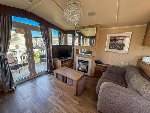 a living room with a couch and a tv at Modern Caravan With Decking Near Scratby Beach Ref 50007E in Great Yarmouth