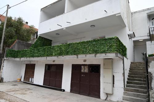 a white building with a green ivy growing on it at Prcanj Seaside Heaven in Prčanj