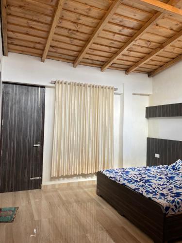 a bedroom with a bed and a large window at KAFAL TREE Home Stay - PET FRIENDLY in Bhowāli