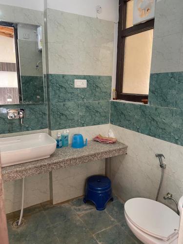 a bathroom with a sink and a toilet at KAFAL TREE Home Stay - PET FRIENDLY in Bhowāli