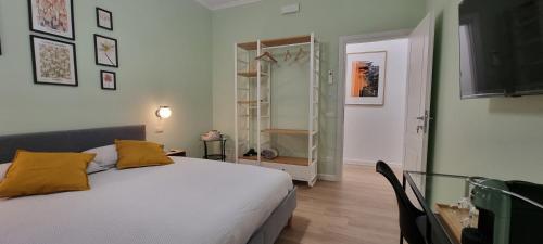 ein Schlafzimmer mit einem weißen Bett und gelben Kissen in der Unterkunft Yuki Apartment in Rom