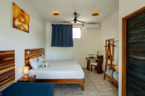 a bedroom with a bed with a blue curtain at Casa Cuyo Hotel in El Cuyo