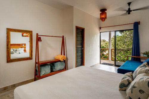 a bedroom with a bed and a mirror and a window at Casa Cuyo Hotel in El Cuyo