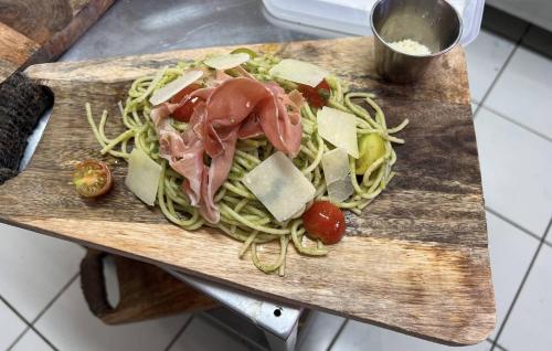 a wooden cutting board with meat and vegetables on it at Guadeloupe 5 Étoiles Front de Mer Rénové 2025 in Saint-François