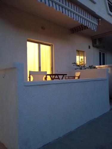 a balcony of a house with a table and a window at Studio Sykea SgS in Xylokastron