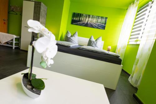 a bedroom with a bed with green walls at Pension Village in Naumburg