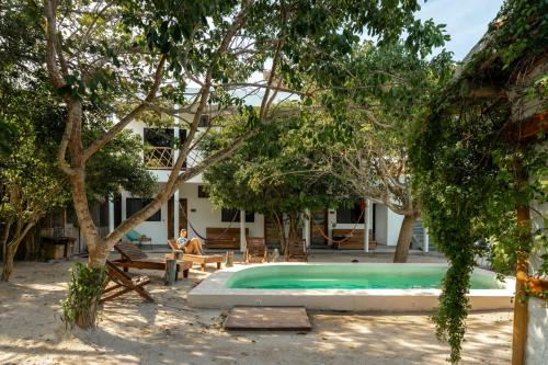 a person sitting in a chair next to a swimming pool at Casa Cuyo Hotel in El Cuyo