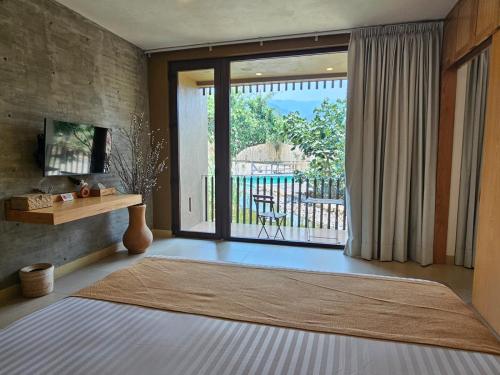 una sala de estar con una gran puerta corredera de cristal en XOLATLACO TEPOZTLAN Hotel Boutique, en Tepoztlán