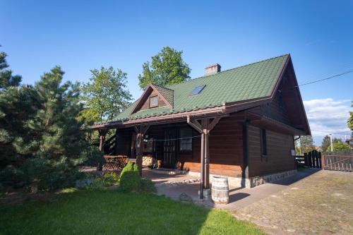 a log cabin with a green roof at Dom pod Lipą in Jaminy