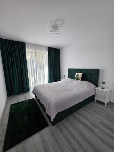 a bedroom with a large bed with green curtains at Luxury BROthers' Apartment in Alba Iulia