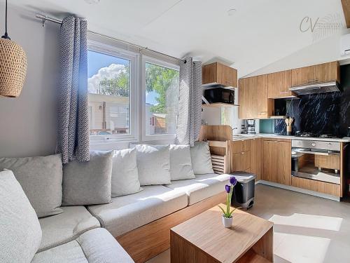 un salon avec un canapé blanc et une cuisine dans l'établissement Mobil-home VI 12 à Vias - La Carabasse - Camping Siblu avec piscine, à Vias