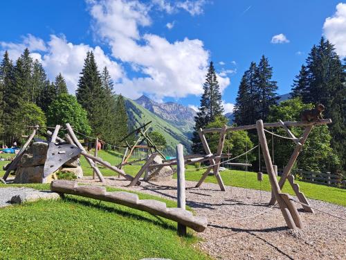 a playground in a park with trees and mountains at Chalet Zur Rose in Berwang bij de piste in Berwang