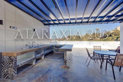 a kitchen with a counter and tables and chairs at Amazing 2 bedrooms apartment with a pool in Sayulita in Sayulita
