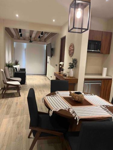 a dining room and living room with a table and chairs at Amazing 2 bedrooms apartment with a pool in Sayulita in Sayulita