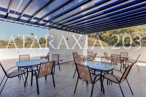 a dining room with tables and chairs and a sign that reads raax at Amazing 2 bedrooms apartment with a pool in Sayulita in Sayulita