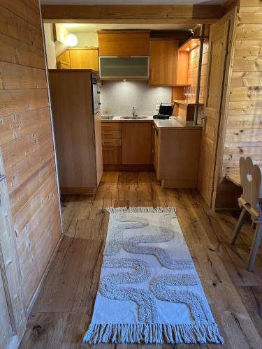 a kitchen with a blue rug on the floor at Ferienwohnungen Hatzl in Neuwald