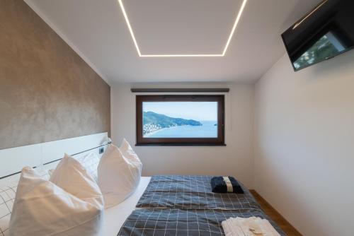 a bedroom with a bed with a window at Spettacolare vista isola Terrazza e idromassaggio in Noli