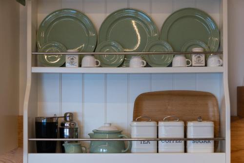a shelf filled with green plates and dishes at Spettacolare vista isola Terrazza e idromassaggio in Noli