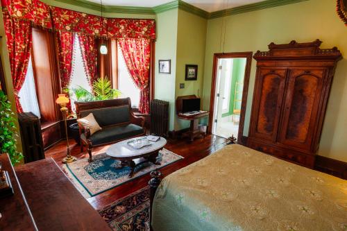 a bedroom with a bed and a chair and a table at Gifford-Risley House Bed and Breakfast in Media