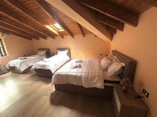 a bedroom with two beds and a wooden floor at Vila Bashllari in Zvarisht
