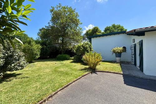 a yard with a house and a driveway at Villa des Landes in Seignosse