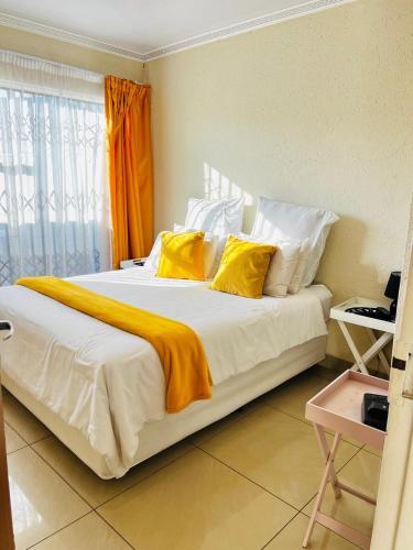 a bedroom with a large bed with yellow pillows at The Barberton Nest in Barberton