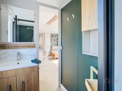 une salle de bain avec un lavabo et un miroir dans l'établissement Mobil-home VI 12 à Vias - La Carabasse - Camping Siblu avec piscine, à Vias