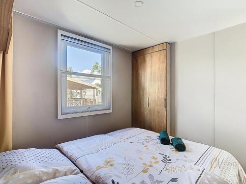 une petite chambre avec un lit et une fenêtre dans l'établissement Mobil-home VI 12 à Vias - La Carabasse - Camping Siblu avec piscine, à Vias