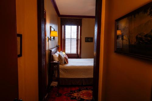 a small bedroom with a bed and a window at Gifford-Risley House Bed and Breakfast in Media