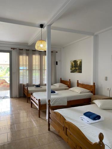 a room with four beds and a pendant light at 4 Seasons apartments in Himare
