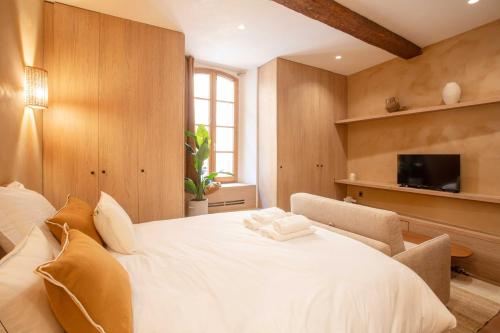 une chambre avec un grand lit blanc et une télévision dans l'établissement Charming Studio with A-C - 2P - Center St Tropez, à Saint-Tropez