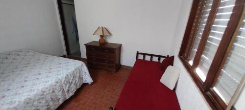 a bedroom with a bed and a dresser with a red carpet at Apartamento 1 dormitorio en Ciudad de Chuy in Chuy