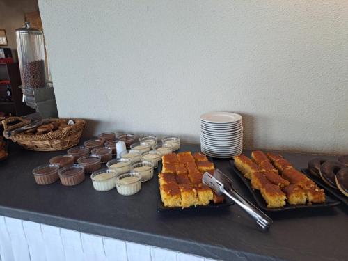 a buffet with cakes and cupcakes on a table at Hotel Atlantis in Corfu Town