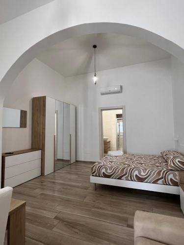 a bedroom with a large bed and an archway at Da MARTINA in Porto Cesareo