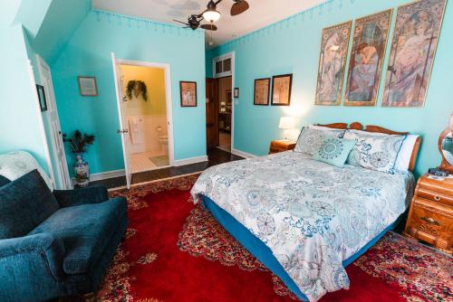 a bedroom with blue walls and a bed and a couch at Gifford-Risley House Bed and Breakfast in Media