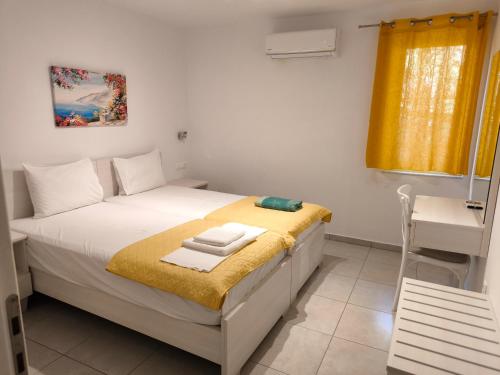 a small bedroom with a bed and a desk at Alexia Rooms in Palaiochora