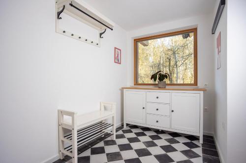 a bedroom with a window and a checkered floor at Haus Malina in Sankt Michael ob Bleiburg
