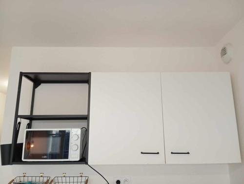 un four micro-ondes installé au-dessus d'un comptoir de cuisine dans l'établissement Luxury apartment, à Gagny