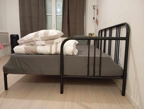 - un lit noir avec des oreillers dans l'établissement Luxury apartment, à Gagny