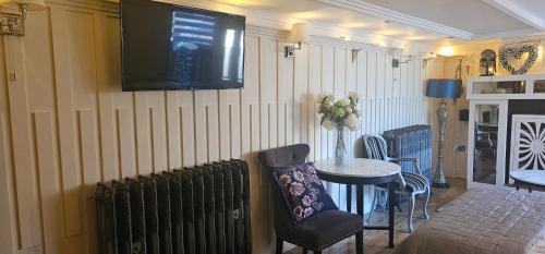 a room with a radiator and a tv on the wall at The Hide Out in Belfast