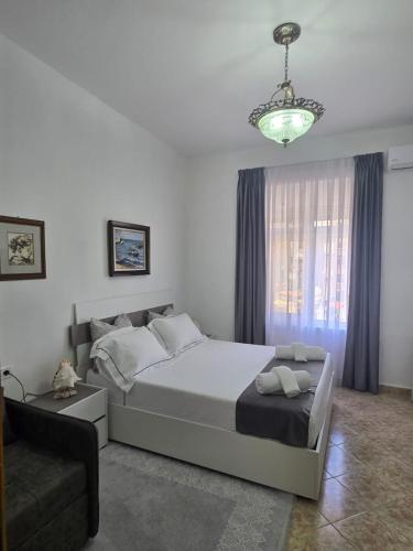 a bedroom with a bed and a couch and a chandelier at Sea view Captain Apartment Durres in Durrës