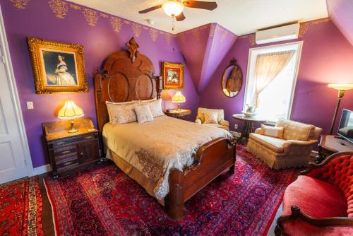 a bedroom with purple walls and a bed and a chair at Gifford-Risley House Bed and Breakfast in Media
