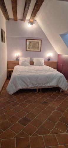 a bedroom with a large bed in a attic at Domaine de la Ferme de Tumbrel in Neuville-Bosc