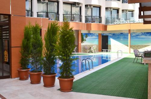 un hotel con piscina y macetas en Hotel By Karaaslan Inn, en Kusadasi